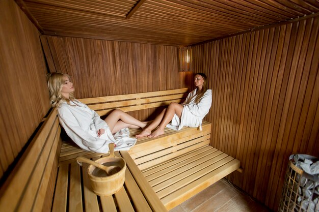 Dos mujeres bastante jóvenes relajantes en la sauna