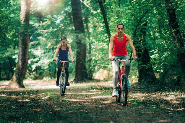 Dos mujeres en bicicleta en el bosque.