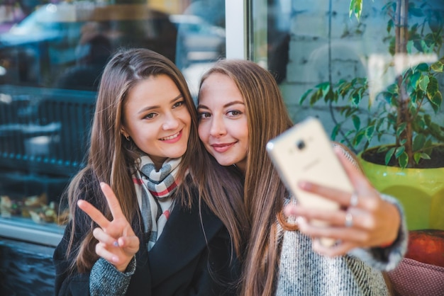 Dos mujeres bonitas se conocieron en un café tomando selfie