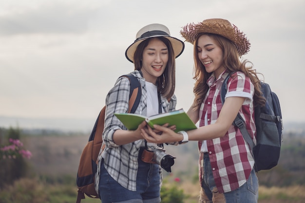 Dos mujeres buscando la dirección en el mapa de ubicación mientras viaja