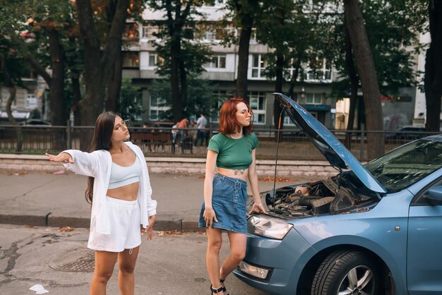 Dos mujeres con el camino del coche roto buscan ayuda