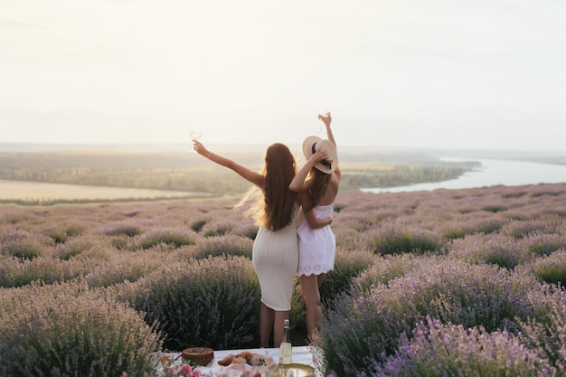 Dos mujeres en un campo de lavanda con vistas al río de fondo