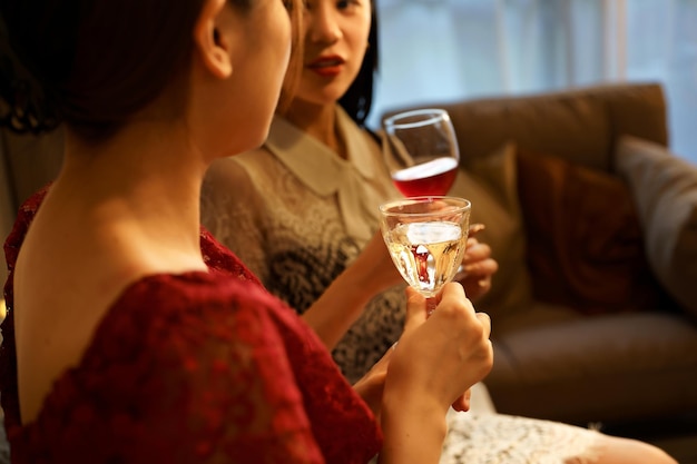 Dos mujeres charlando con un vaso en la mano