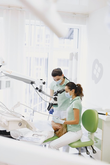 Dos mujeres en una clínica dental mirando un microscopio