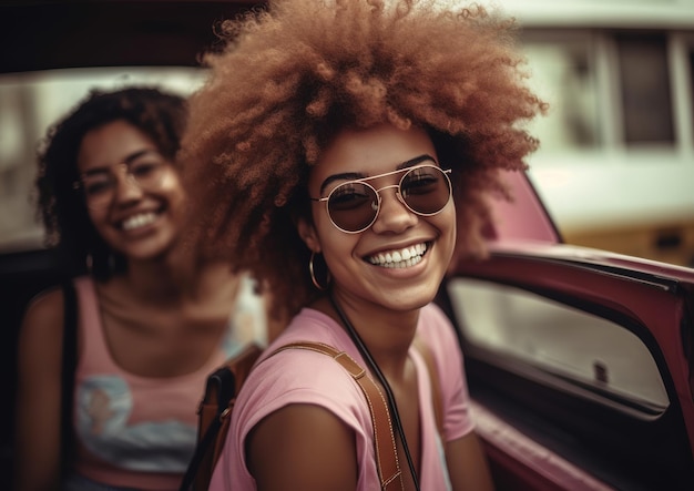 Dos mujeres en un coche sonriendo a la cámara.