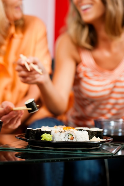 Foto dos mujeres comiendo sushi