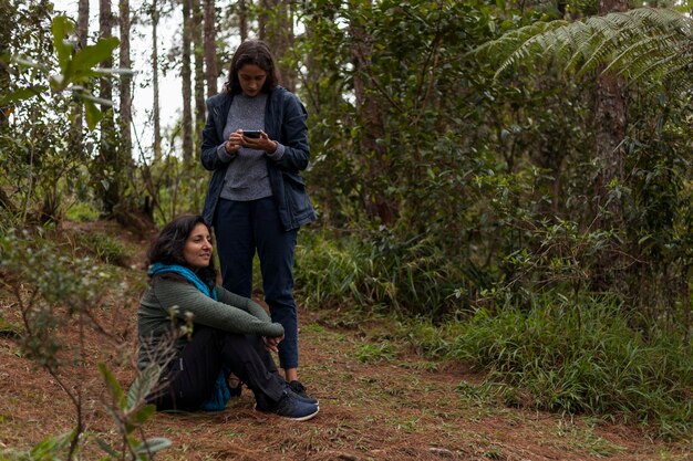 Dos mujeres disfrutando de un día en el bosque de pinos Concepto de medio ambiente día de la tierra