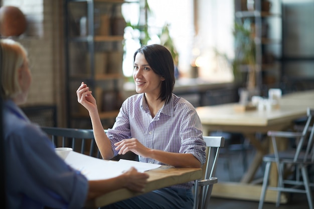 Dos mujeres disfrutando de una reunión de trabajo en café