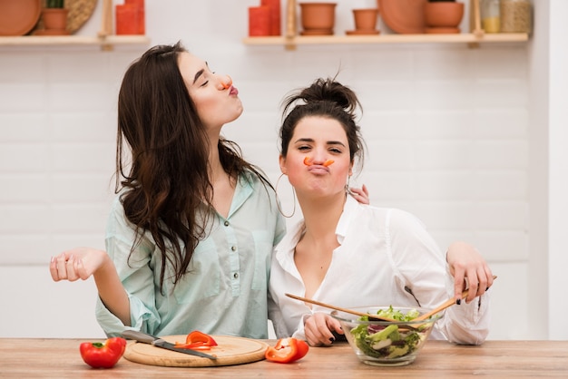 Dos mujeres se divierten con pimiento rojo como bigote