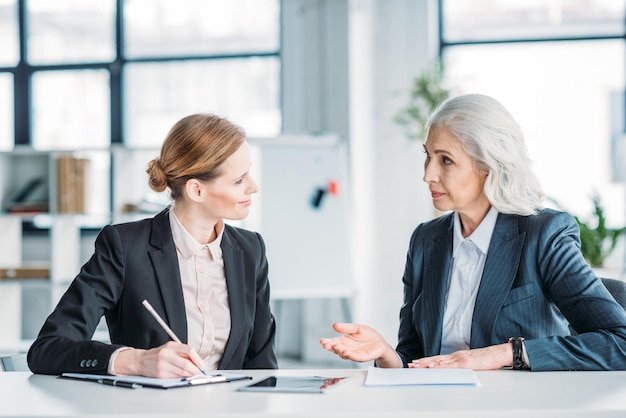 Dos mujeres empresarias discutiendo el proyecto empresarial en la reunión en la oficina