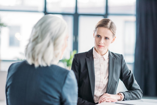 Dos mujeres empresarias discutiendo el proyecto empresarial en la reunión en la oficina