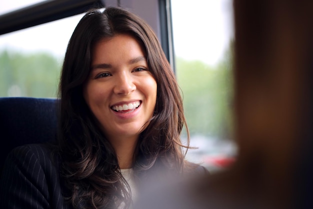 Dos mujeres empresarias que viajan al trabajo en tren hablando juntas en el carro