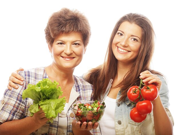 Dos mujeres con ensalada y verduras.