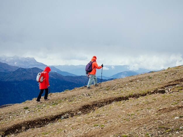 Dos mujeres están de excursión en las montañas en otoño.