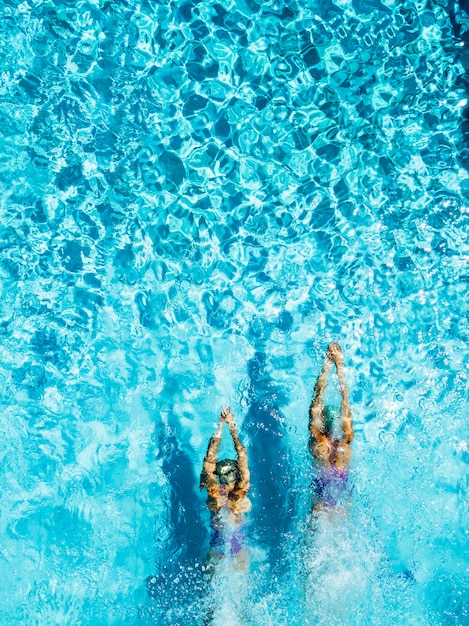 Dos mujeres están nadando en una piscina, vista desde arriba.