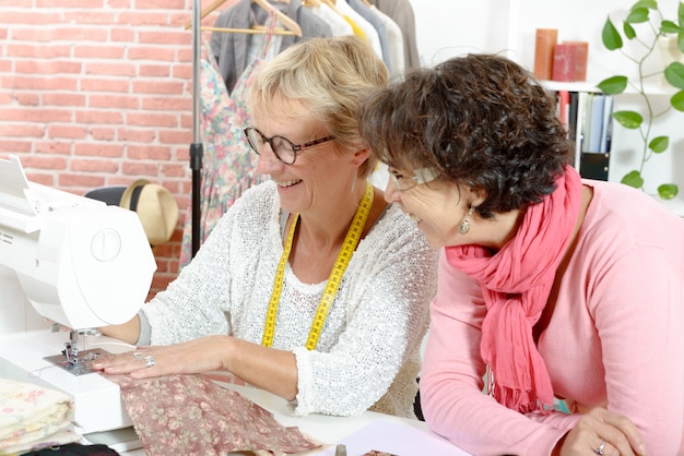 Dos mujeres felices cosiendo en su taller