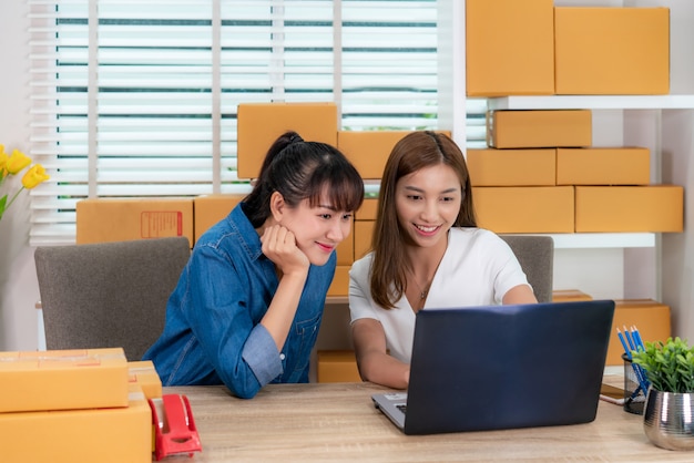 Dos mujeres frente a una computadora portátil en un escritorio