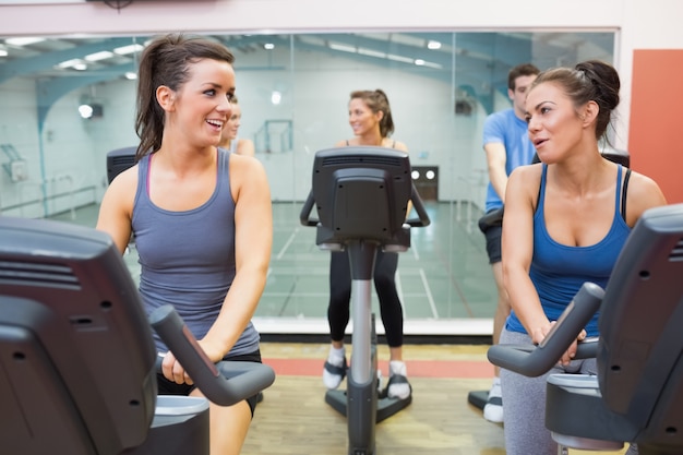 Dos mujeres hablando mientras entrenaban en una clase de spinning