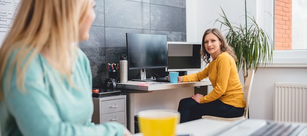 Dos mujeres hablando en la oficina