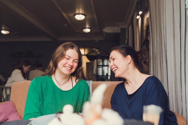 Dos mujeres hablando y tomando café en la cafetería