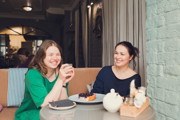 Dos mujeres hablando y tomando café en la cafetería