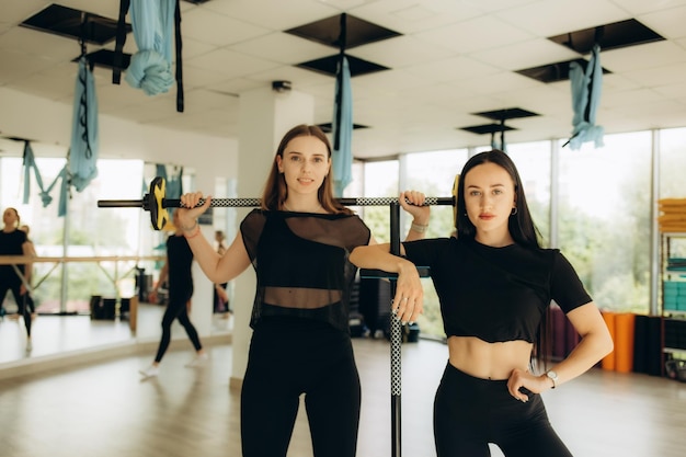 dos mujeres hacen fitness con barras entrenador de fitness