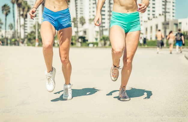 Dos mujeres haciendo correr intenso en la playa de Venecia