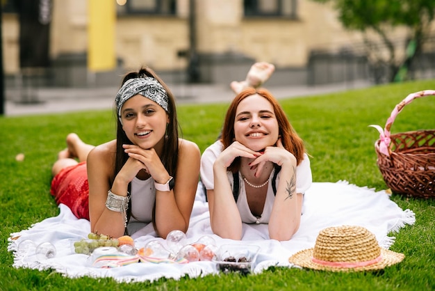 Dos mujeres haciendo un picnic juntas en el césped del parque