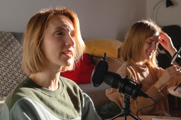 Dos mujeres haciendo podcast juntas en casa