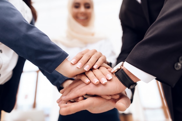 Dos mujeres y un hombre se dan la mano.