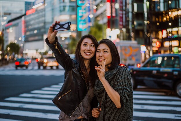 Dos mujeres japonesas en Tokio durante el día. Hacer compras y divertirse