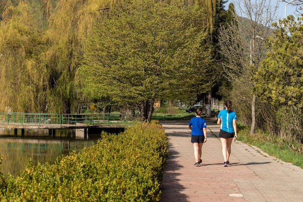 Dos mujeres jóvenes caminando por el sendero cerca del lago de la ciudad en Dilijan Armenia