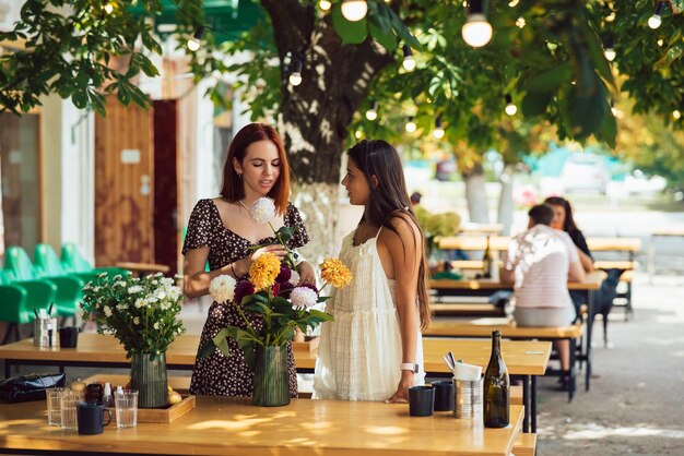 Dos mujeres jóvenes componen un hermoso ramo festivo