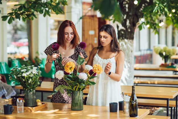 Dos mujeres jóvenes componen un hermoso ramo festivo