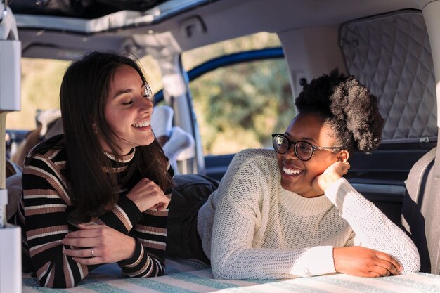 Dos mujeres jóvenes disfrutando de la relajación de la vida de la furgoneta