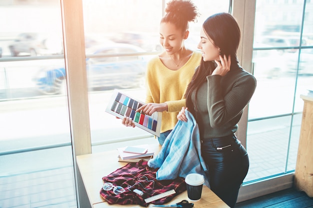 Dos mujeres jóvenes juntas y trabajando para el mismo proyecto de moda.