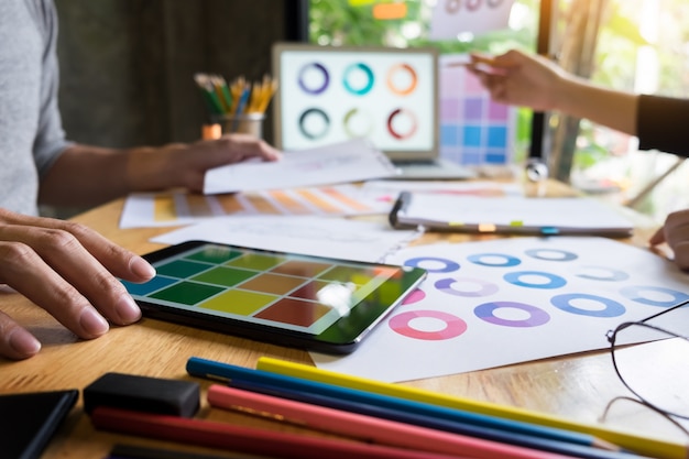 dos mujeres jóvenes que trabajan como diseñadores de moda y dibujar bocetos y obtiene asesoramiento de tela en un sastre personalizado