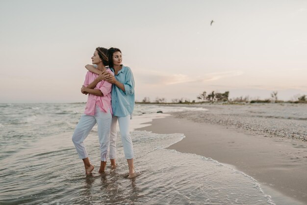 dos, mujeres jóvenes, tener diversión, en la playa