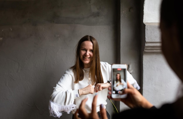 Dos mujeres jóvenes se toman fotos y videos en un teléfono inteligente en una terraza