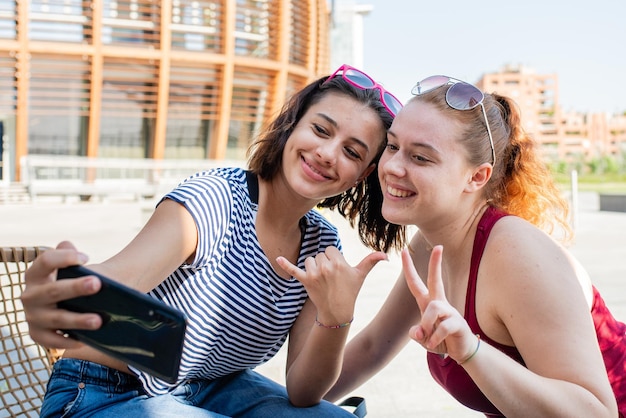 Dos mujeres jóvenes tomándose un selfie, un par de chicas turistas por la ciudad