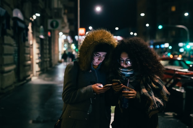 Foto dos, mujeres jóvenes, utilizar, smartphone