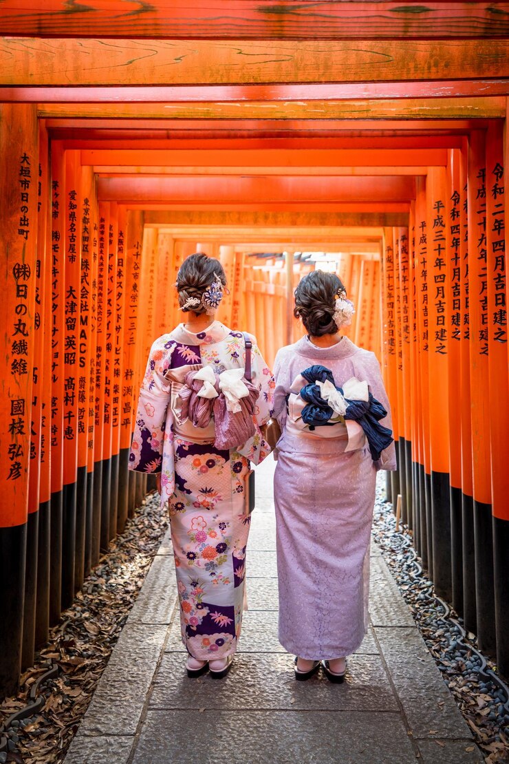 Dos mujeres con kimonos están caminando en el santuario Fushimi Inari Taisha Senbon Torii Gate Kyoto Japón