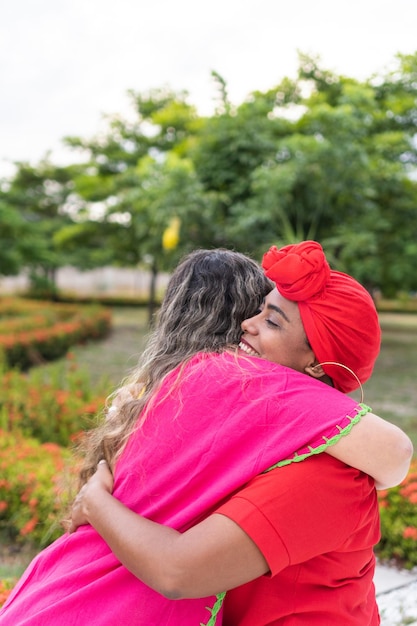 Dos mujeres latinas se abrazan en el parque de la ciudad