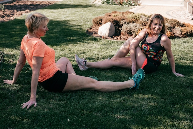 Dos mujeres mayores activas haciendo yoga al aire libre, son felices y amigables, entrenamiento deportivo