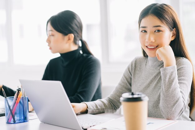 Dos mujeres de negocios asiáticas se reúnen en la oficina