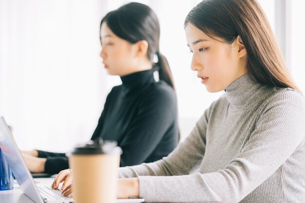 Dos mujeres de negocios asiáticas se reúnen en la oficina