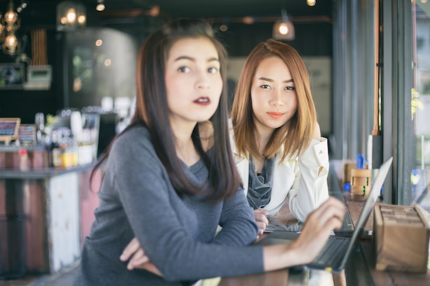 Dos mujeres de negocios asiáticos que usan el trabajo del cuaderno y la discusión del contrato importante en la oficina,