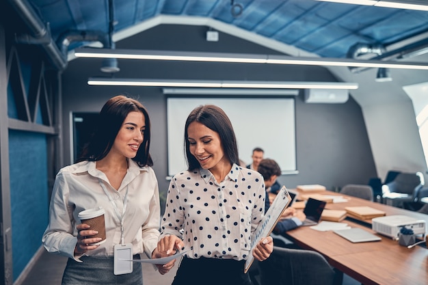 Foto dos mujeres de negocios están hablando en la oficina