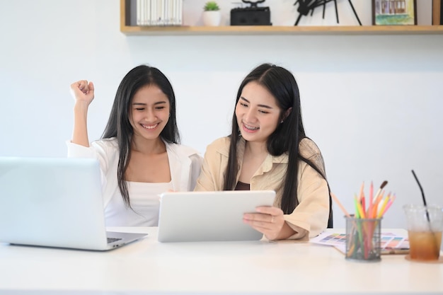 Dos mujeres de negocios que se sienten felices y celebran el éxito empresarial.