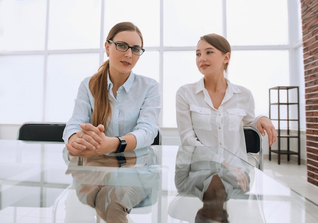 Dos mujeres de negocios sentadas en una mesa en la sala de conferenciasfoto con espacio para copiar